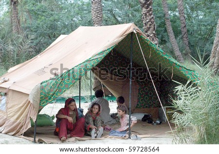 DHADAR, PAKISTAN - AUG 20: A flood affected family sits at their makeshift tent  house at a flood relief camp established by FC on August 20, 2010 in Dhadar.