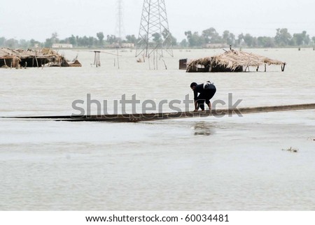 SUKKUR, PAKISTAN - AUG 27: Resident of Sultan Kot uses railway tracks to move towards a safe place after flood in the area of Sultan on August 27, 2010 in Sukkur.