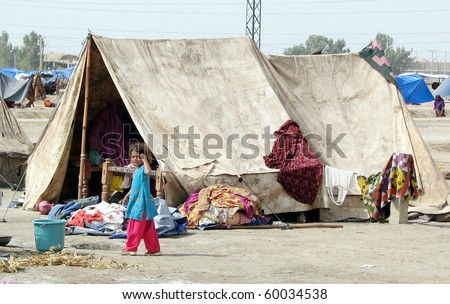 HYDERABAD, PAKISTAN - AUG 28: A flood-affected girl stands near her makeshift tent house at a flood-affectee relief camp on August 28, 2010 in Hyderabad.