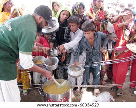 HYDERABAD, PAKISTAN - AUG 28: Flood-affected people gather to receive food at relief camp on August 28, 2010 in Hyderabad.
