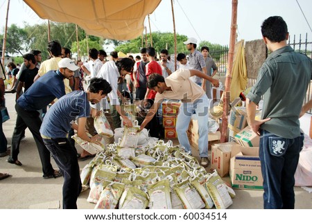 KARACHI, PAKISTAN - AUG 29: Student volunteers help unload and organize relief goods brought by citizens to PAF Base Shahrah-e-Faisal on August 29, 2010 in Karachi