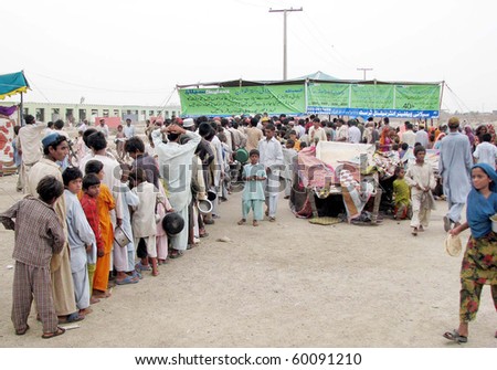HYDERABAD, PAKISTAN - AUG 30: Flood affected people stand in line at a Selani Welfare Trust stall during distribution of food at a relief camp on August 30, 2010 in Hyderabad. Camp is established at Hala.