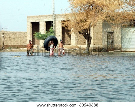 DERA ALLAHYAR, PAKISTAN-SEPT 02: Flood affected men pass through flood water at a flood hit area on Thursday, September 02, 2010 in Dera Allahyar (Arsalan Naseer/PPI Images).