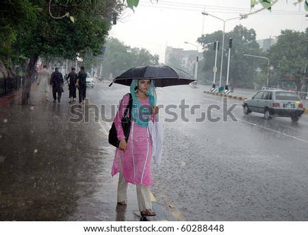 LAHORE, PAKISTAN-SEPT 02: A girl holds umbrella over her head passes through Mall  road during heavy downpour in Lahore on Thursday, September 02, 2010.  (Babar Shah/PPI Images).