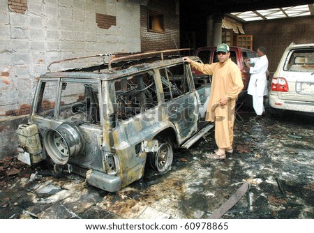 QUETTA, PAKISTAN - SEPT 9: People look at damaged vehicles destroyed in bomb explosion in Quetta, Pakistan on Sept 09, 2010
