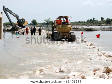 SUKKUR PAKISTAN -SEPT 15: Frontier Works Organization (FWO) workers busy in  repairing of Breach at Tori Bund while villages in Sehwan and Johi continued to flood. Taken Sept. 15, 2010 in Sukkur, Pakistan.