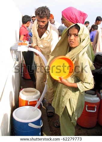 KARACHI, PAKISTAN, SEPT 30: Flood affected people fill their drinking water coolers at  drinking water tank at flood affectees relief camp established at Hawks bay area on September 30, 2010 in Karachi, Pakistan.