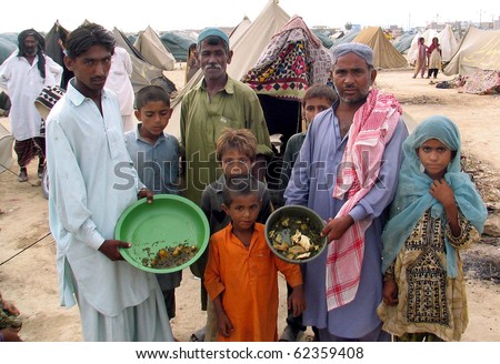 KARACHI, PAKISTAN, OCT 03: Flood affectees people hold their food pots as they are  protesting against providing of allegedly substandard food, at relief camp established at Hawks Bay area on October 3, 2010 in Karachi, Pakistan.