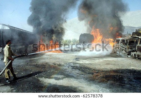 QUETTA, PAKISTAN - OCT 06: Firefighter extinguishes fire of burning NATO oil tankers following armed attack on October 06, 2010 in Quetta, Pakistan