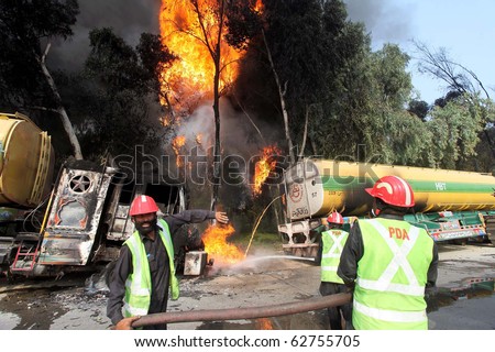 NOWSHERA, PAKISTAN - OCT 07: Firefighters extinguish fire of burning NATO oil tankers following armed attack, on October 07, 2010 in Nowshera, Pakistan