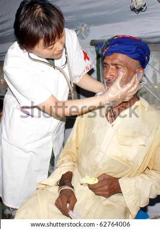 SEHWAN, PAKISTAN - OCT 09: Chinese doctor examines patients at free medical camp for flood affectees established by China Army on October 09, 2010 in Sehwan, Pakistan.