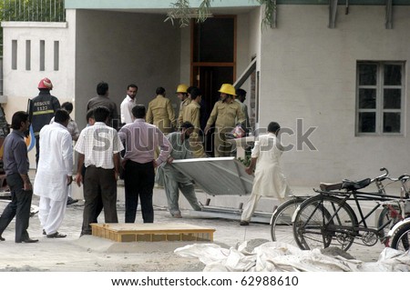 LAHORE, PAKISTAN - OCT 13: People gather after gas-cylinder blast in canteen at Shaheen Complex building on October 13, 2010 in Lahore, Pakistan.