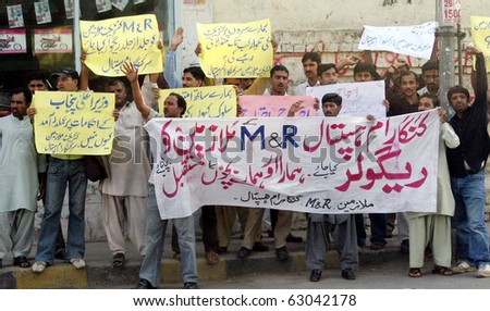 LAHORE, PAKISTAN - OCT 14: Employees of Sir Ganga Ram hospital chant slogans for regularization of their jobs during protest demonstration at Mall road on October 14, 2010 in Lahore.