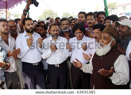 KARACHI, PAKISTAN - OCT 20: People offer Dua (pray) during funeral prayer of those who were lost their lifes in firing incident yesterday at Sher Shah Market Oct 20, 2010 in Karachi.