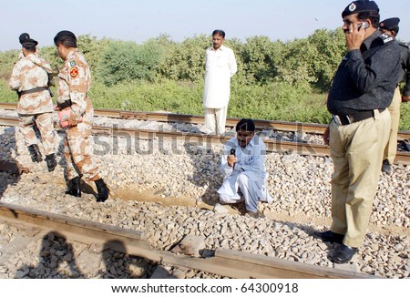 HYDERABAD, PAKISTAN - NOV 02: Rangers and police officials stand at damaged portion of railway track that was destroyed in bomb explosion, on Tuesday, November 02, 2010 in Hyderabad, Pakistan.