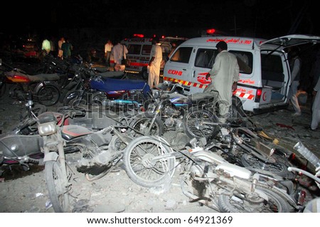 KARACHI, PAKISTAN - NOV 11: People gather near damaged motorcycles which were destroyed in explosion, after explosion at the site on November 11, 2010 in Karachi, Pakistan.
