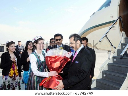 DUSHANBE, TAJIKISTAN - NOV 24: Tajik girl presents bouquet to Prime Minister, Syed Yusuf Raza Gilani, upon his arrival at Dushanbe Airport on November 24, 2010.