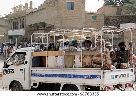 KARACHI, PAKISTAN - DEC 07: Rangers officials escort arrested people on vehicle after their arrest during search operation at Nusrat Bhtto Colony on December 07, 2010 in Karachi, Pakistan.