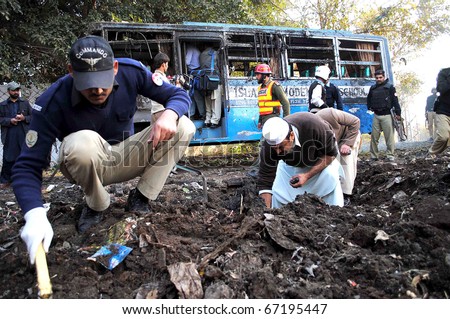 PESHAWAR, PAKISTAN - DEC 13: Security officials investigating the explosion site after a school bus exploded through a road side bomb on December 13, 2010 in Peshawar, Pakistan