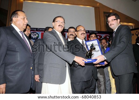 KARACHI, PAKISTAN - DEC 30: Federal Minister for Commerce, Makhdoom Amin Fahim, gives away Consumer Choice Award 2010 to Meiji Pakistan Chief Executive, S.M Uzair on December 30, 2010 in Karachi.