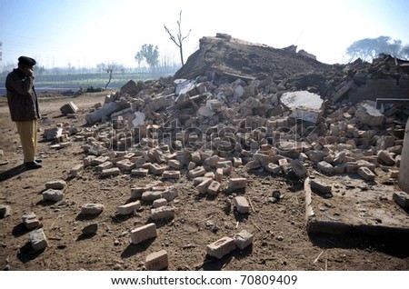 PESHAWAR, PAKISTAN - FEB 08: Police official inspects debris of check-post which was destroyed in explosion after explosion at the site on February 08, 2011in Peshawar.