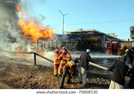PESHAWAR, PAKISTAN - FEB 08: Fire fighters extinguish fire on burning oil-tankers and vehicles which were caught fire after attack by unknown miscreants at Jamrud road on February 08, 2011in Peshawar.