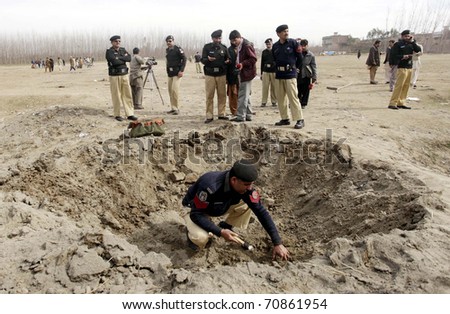 CHARSADDA, PAKISTAN - FEB 09: Police officials inspect the site of explosion after bomb explosion on February 09, 2011in Charsadda.