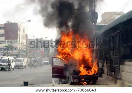 LAHORE, PAKISTAN - FEB 09: Fire flames and smoke rise from burning vehicle which was caught fire due to electric-shot-circuit at public service commission office on February 09, 2011in Lahore.
