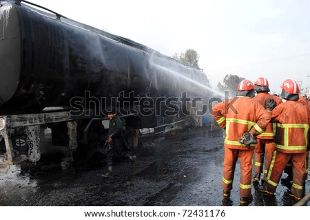 PESHAWAR, PAKISTAN - MAR 03: Firefighters extinguish fire on burning NATO oil-tanker after unidentified miscreants attack at Jamrud road on March 03, 2011in Peshawar.