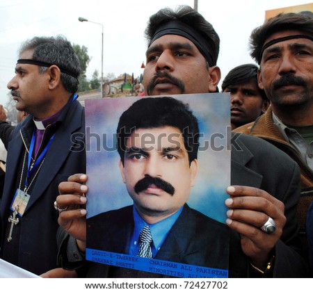 PESHAWAR, PAKISTAN - MAR 03: Christian man holds picture of slain Federal Minister for Minorities Affairs, during protest demonstration against his assassination on March 03, 201 in Peshawar.