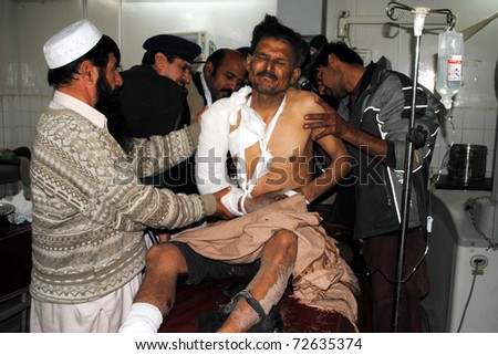 PESHAWAR, PAKISTAN - MAR 05: Paramedic staff treats injured man who was injured in hand-grenade attack at F.C Check post in Bara Shahi khan, at Lady Reading hospital on March 05, 2011in Peshawar.