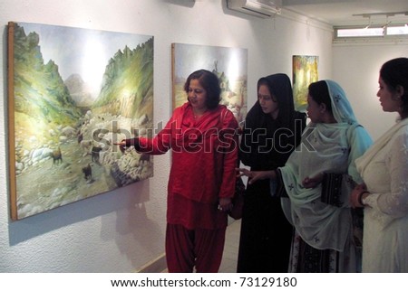 KARACHI, PAKISTAN - MAR 13: Women take keen interest in paintings exhibition of Famous Artist Gohar Jee arranged by Arts Council (ACP) held on  March 13, 2011 in Karachi.