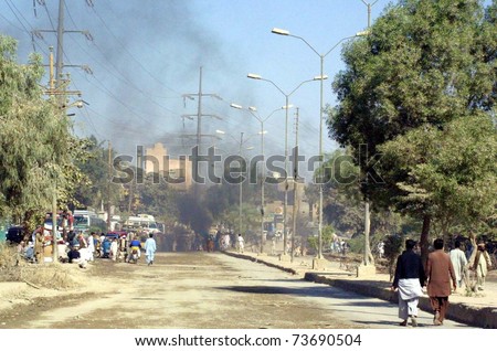 KARACHI, PAKISTAN - MAR 21: Smoke rises at a road as angry mob burn tires as violence erupts in city after incidents of the target-killings in different areas of the city on March 21, 2011 in Karachi.