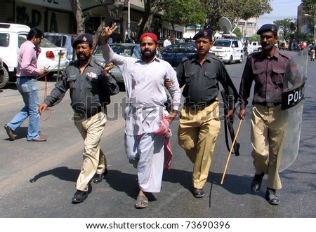 KARACHI, PAKISTAN - MAR 21: Policemen arrest protester during protest rally of All Sindh Lower Staff Association in favor of their demands on March 21, 2011 in Karachi.