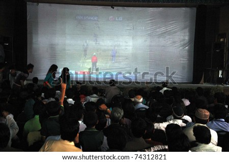 KARACHI, PAKISTAN - MAR 30: Cricket fans  watch a telecast of the Cricket World Cup semi-final match between Pakistan and India on a large screen on March 30, 2011 in Karachi.