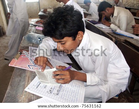 BADIN, PAKISTAN - APR 19: Students copy examination papers during the Annual Matriculation Examination at an examination hall at Rahim School and College on April 19, 2011 in Badin.