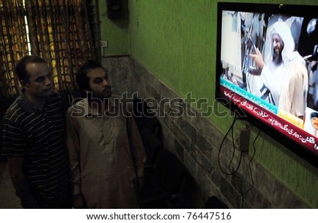 PESHAWAR, PAKISTAN - MAY 02: People watch a TV news report about the killing of Al- Qaida leader Osama Bin Laden, on May 02, 2011 in Peshawar, Pakistan.