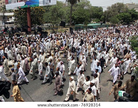 KARACHI, PAKISTAN - MAY 09: Dismissed employees of electric supply company (KESC) pass through a road during protest rally for restoration of their jobs on May 09, 2011 in Karachi.