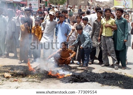 HYDERABAD, PAKISTAN - MAY 15: Angry residents burn bushes at a road as they protest against electricity load-shedding in their area at Khawaja Ghareeb Nawaz Colony on May 15, 2011 in Hyderabad.