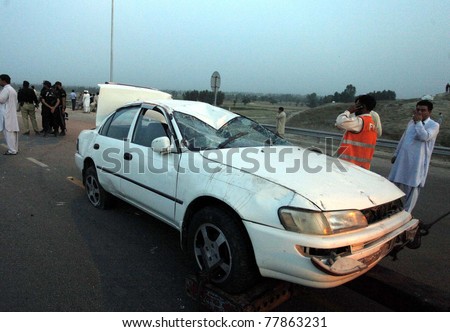 NOWSEHRA, PAKISTAN - MAY 23: People gather near damaged vehicle which was destroyed in explosion on May 23, 2011in Nowshera, Pakistan.