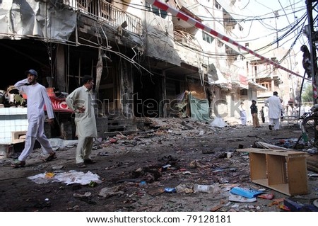 PESHAWAR, PAKISTAN - JUN 12: People gather near damaged shops which were destroyed in explosions after two explosions at Khyber Supermarket, on early morning on June 12, 2011 in Peshawar.