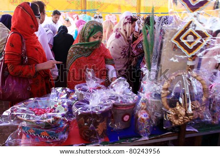 NOWSHERA, PAKISTAN - JUN 29: Women look at home decoration items during Handmade exhibition arranged by an NGO held at Jalozai camp on June 29, 2011in Nowshera, Pakistan.