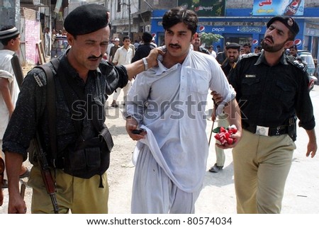 PESHAWAR, PAKISTAN - JUL 06: Policemen escort a protester after his arrest during protest demonstration of Tehreek-e-Insaf (PTI) in favor of their demands at Yakatoot on July 06, 2011 in Peshawar.