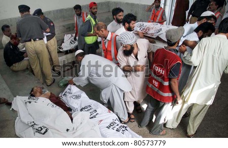 KARACHI, PAKISTAN - JUL 6: People look at dead bodies of five men which were found in a passenger mini-bus at Gulshan-e-Iqbal area, at Jinnah hospital on  July 6, 2011 in Karachi.