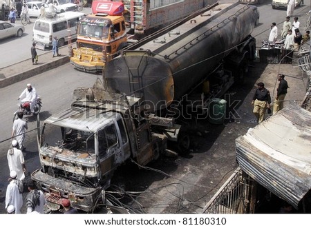 PESHAWAR, PAKISTAN - JUL 17: People look at burnt NATO oil-tanker which was destroyed  due to militants attack last night, on July 17, 2011in Peshawar, Pakistan.