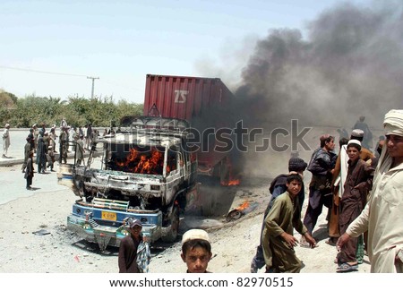 CHAMAN, PAKISTAN - AUG 16: People gather near burning NATO truck which was set ablaze by angry protesters during protest demonstration against killing of men on August 16, 2011in Chaman, Pakistan
