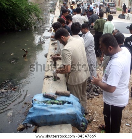 KARACHI - SEPT 12: Police officials inspect seized explosive materials which were recovered from sewerage water drain at Soldier Bazaar in Karachi on September  12, 2011.