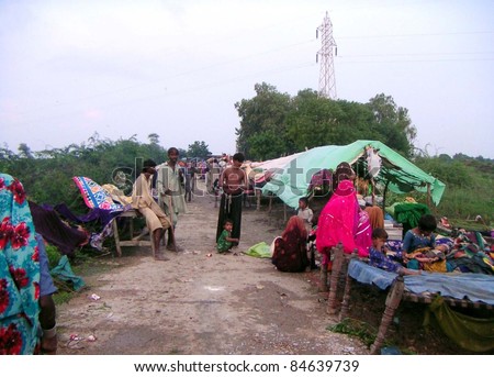 KUNRI, PAKISTAN: Rain-affected people with their households are living under the open sky as their homes were inundated due to heavy downpour of Monsoon Season in Kunri, Pakistan on September 13, 2011.