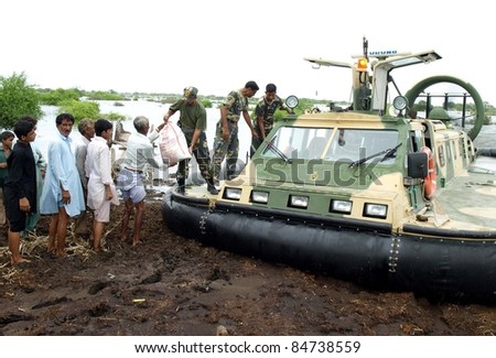 KARACHI, PAKISTAN - SEPT. 15: Navy soldiers distribute ration among flood affected people at a flood hit area of Sindh province, Pakistan on September 15, 2011.
