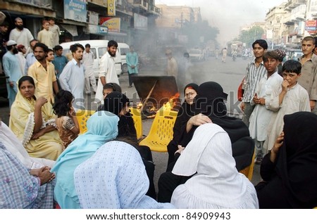 KARACHI, PAKISTAN - SEPT 17: Residents of Light House gather near burning wooden stuff at a road as they are protesting against non-supply of electricity on September 17, 2011 in Karachi.